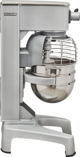 A silver Hobart 30 quart planetary mixer with a large stainless steel bowl and wire safety guard. This industrial-grade mixer is built for heavy-duty mixing, stands on sturdy legs, and is photographed from the side.