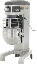 A large, industrial Legacy Planetary Mixer with a 30 qt metal bowl, protective wire guard, and control panel featuring knobs and buttons. The machine is grey and silver, with sturdy legs and a side lever for adjusting the mixing bowl’s height.