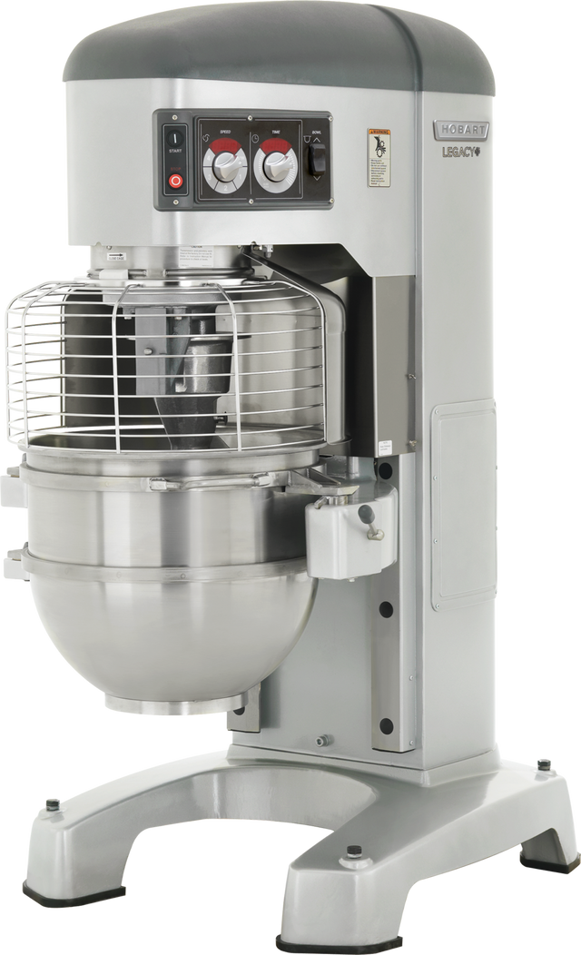 A large industrial planetary mixer with a stainless steel mixing bowl and a protective wire guard. This 80 quart mixer, labeled “Hobart Legacy,” is gray with control knobs on the front and stands on four sturdy legs.