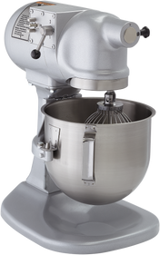 A silver Hobart mixer with a large stainless steel mixing bowl and wire whisk attachment. The sturdy, heavy-duty planetary bench mixer features a speed control lever, side instructions label, and is ideal for commercial use.