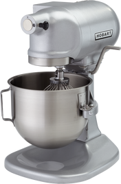 A silver Hobart N50 mixer with a large stainless steel mixing bowl and wire whisk attachment. This 5 quart planetary bench mixer features a side lever and rounded, industrial design, perfect for mixing dough and batter in professional kitchens.