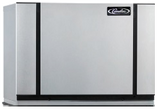 A large, rectangular, silver metal Modular Ice Maker with black vertical lines on either side and the “Cummins” logo in the upper right corner. The air-cooled device sits on a flat surface and has a minimalist, clean design.