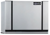 A large, rectangular, silver metal Modular Ice Maker with black vertical lines on either side and the “Cummins” logo in the upper right corner. The air-cooled device sits on a flat surface and has a minimalist, clean design.