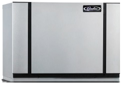 A large, rectangular, silver metal Modular Ice Maker with black vertical lines on either side and the “Cummins” logo in the upper right corner. The air-cooled device sits on a flat surface and has a minimalist, clean design.