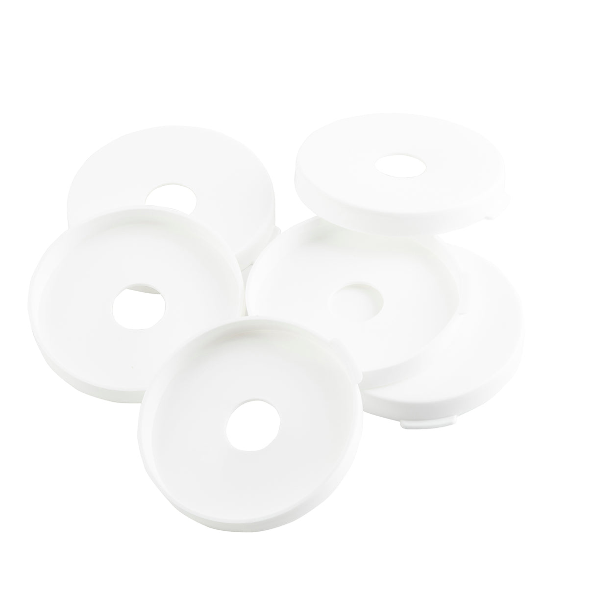 Five round, white plastic lids with a central circular hole are stacked and overlapping each other on a white background. These dishwasher safe Pump Snap Caps from TableCraft Products feature smooth surfaces and slightly raised edges.