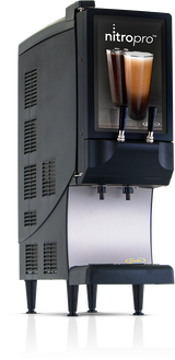 A black and silver NitroPro Mini Cold Brew Dispenser with two taps displays two glasses of layered nitro coffee. This countertop cold brew dispenser stands on four legs with a metal drip tray beneath the taps and is labeled nitropro at the top.