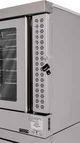 Close-up of a stainless steel commercial convection oven with a glass window on the door. This double-deck oven features a vented metal panel with keyhole, two keys hanging from a lock, and various caution and product labels below the panel.