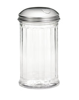A clear, empty glass sugar dispenser with vertical ribbed sides and a shiny stainless steel lid featuring a small, curved cutout for pouring. The pourer is set against a plain white background.