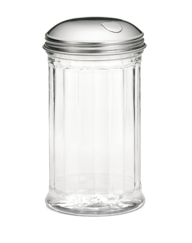 A clear, empty glass sugar dispenser with vertical ribbed sides and a shiny stainless steel lid featuring a small, curved cutout for pouring. The pourer is set against a plain white background.