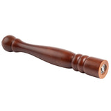 A TableCraft pepper mill crafted from rich mahogany wood lies diagonally on a white background, featuring a rounded top, tapered middle, and grooved accents near the grinding end that reveals its metal grinder mechanism.