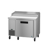 A Hoshizaki stainless steel pizza prep table on wheels with a top lid, cutting board, and refrigerated storage. The front has a digital display, ventilation panel, and a single door with recessed handle for convenience and style.