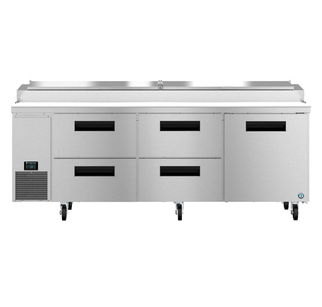 A large Hoshizaki Steelheart pizza prep table with a flat stainless steel top, six black-handled drawers, and wheels for mobility. The left side features a digital temperature display panel and vent, plus a raised section for ingredient storage.