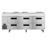 A large commercial stainless steel pizza prep table with six black-handled refrigerated drawers, a digital control panel on the left, and four caster wheels. The top features a covered compartment for food storage or ingredients.