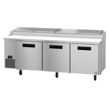 A large Hoshizaki Steelheart stainless steel pizza prep table with three front doors, digital temperature display on the left, top lid ingredient storage sections, black handles, and caster wheels for mobility.