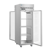 A tall Hoshizaki Steelheart Series Refrigerator with glass doors stands open, revealing three adjustable wire shelves inside. This pass-thru refrigerator features a digital display above the doors and four wheels for mobility at the base.