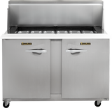 A compact prep table refrigerator with two doors, a raised shelf, and six food pans on top. The stainless steel unit features handles labeled True, sits on wheels for mobility, and has a clean surface—appearing new and unused.