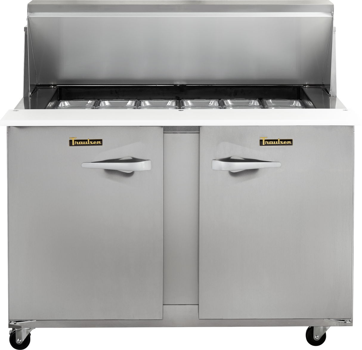 A Traulsen stainless steel compact prep table refrigerator features six covered compartments on top, a raised backsplash, two cabinet doors with handles below, and four wheels for mobility. The brand name is visible on both doors.