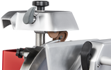 Close-up of a Berkel Fly Wheel Slicer’s blade sharpening mechanism, featuring a chromium-plated carbon steel knife, metal and plastic parts, a brown sharpening stone, adjustment knobs, and a red section against a black background.
