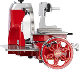 A red and silver vintage-style Berkel Fly Wheel Slicer features a chromium-plated carbon steel knife, stainless steel blade guard, tray, and gears, with a large hand-crank wheel, viewed from the side on a white background.
