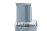 A close-up of a Robot Coupe R101P Combination Food Processor part, featuring a cylindrical chute for the vegetable prep function on a transparent lid with locking tabs. The background is plain white.