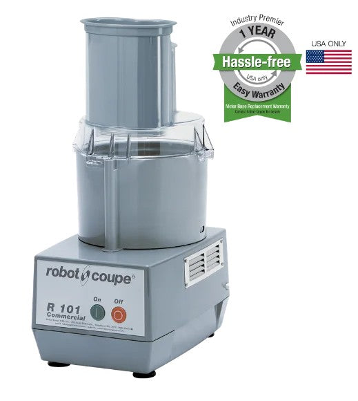 A silver Robot Coupe R101P Combination Food Processor with a clear bowl and lid sits on a white background. A green and gray badge advertises a 1-year hassle-free warranty, while a small American flag appears beside it.