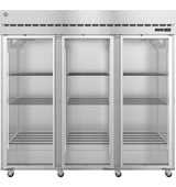 A large, commercial stainless steel refrigerator with three glass doors. Each section of this reach-in refrigerator has adjustable wire shelves and is empty. The unit stands on wheels, with a digital control panel on the upper right corner.
