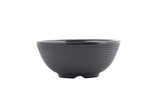 A matte black ceramic bowl with a subtle horizontal ribbed texture, wide rim, and gently curved sides, viewed against a plain white background. This stylish bowl is dishwasher safe and features a small, slightly elevated base.