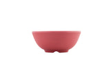 A small, round, ridged 2 oz ramekin in matte pink ceramic is centered on a white background. The bowl has a slightly flared lip and sits on a short, footed base. The simple, modern design emphasizes its textured surface.