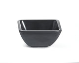 A square-shaped black melamine bowl with gently flared sides and horizontal textured ridges on the exterior, resting on a white background. The bowl has a glossy interior, matte finish outside, and is dishwasher safe.