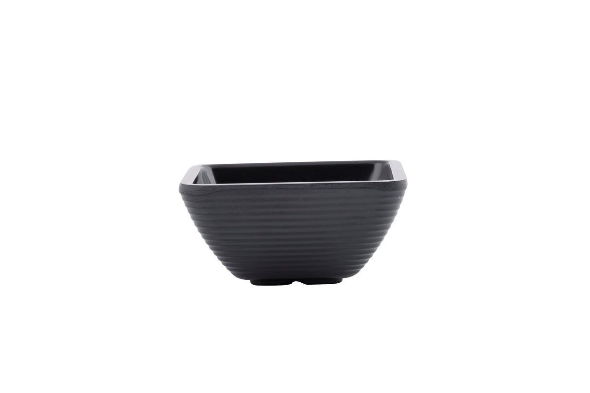 A small, black, square-shaped melamine bowl with gently ridged sides and a matte finish is centered on a white background. The minimalist ramekin design is both modern and dishwasher safe.