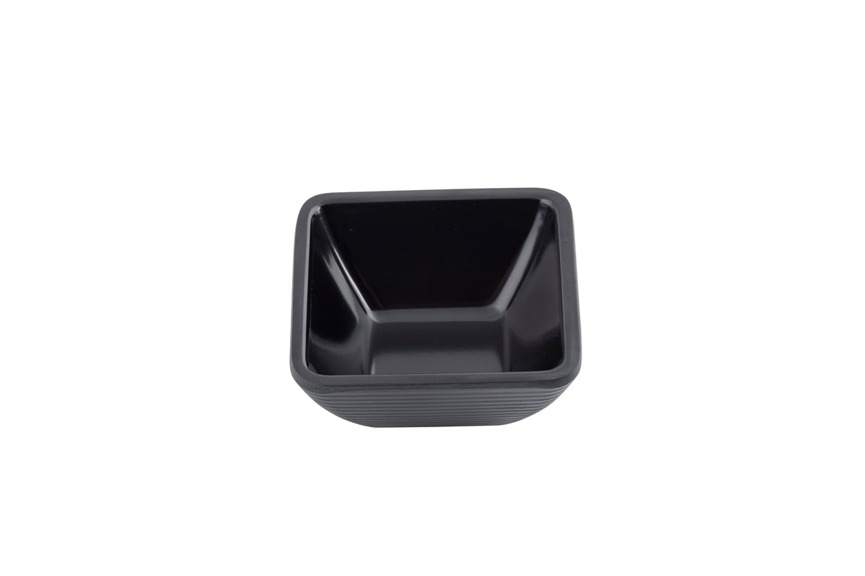 A small, empty, square-shaped black melamine bowl with slightly flared sides sits against a white background. The bowl appears to have a smooth, glossy interior and a matte, textured exterior, and is dishwasher safe.