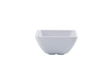 A small, white, square ceramic ramekin with slightly flared sides and a ridged texture. The glossy, empty bowl is placed against a plain white background.