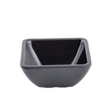 A small, empty, square-shaped ramekin made of dark grey ceramic with a glossy finish and subtle horizontal ridges on its outer surface, shown against a plain white background.