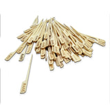 A pile of TableCraft bamboo Meat Marker Picks, each with a flat end engraved with "RARE" in black lettering. One pick is separated from the group in the foreground, all set against a white background.
