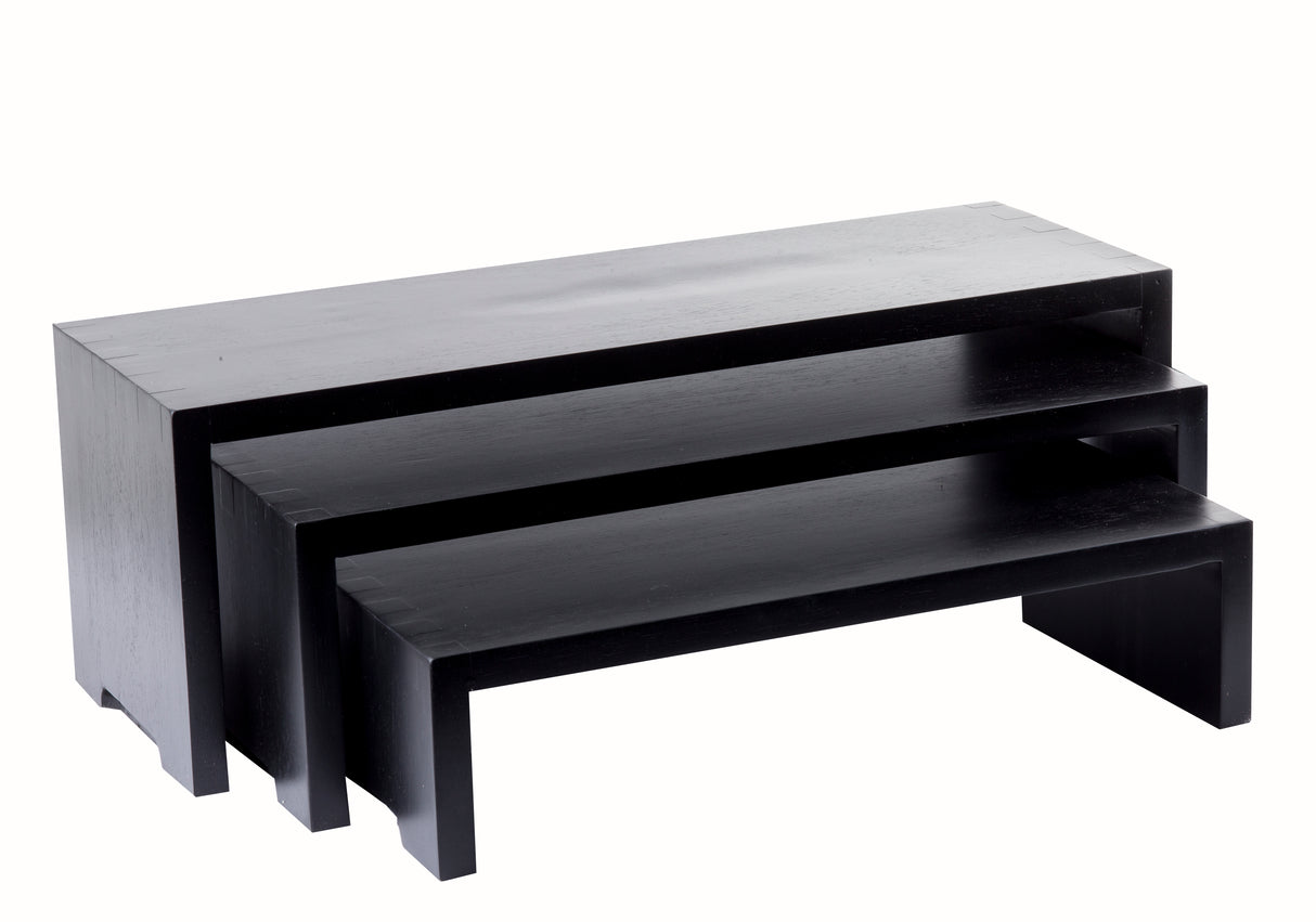 Three black rectangular Cascade Risers form a sleek nesting set, stacked together for a modern, minimalist look. Each TableCraft Products table features clean lines and a solid, blocky shape against a plain white background.