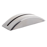 A shiny, curved, metallic object with a smooth surface and a single narrow slit across its top; this stainless steel piece by TableCraft rests on a white background and resembles a modern, minimalist napkin or card holder.
