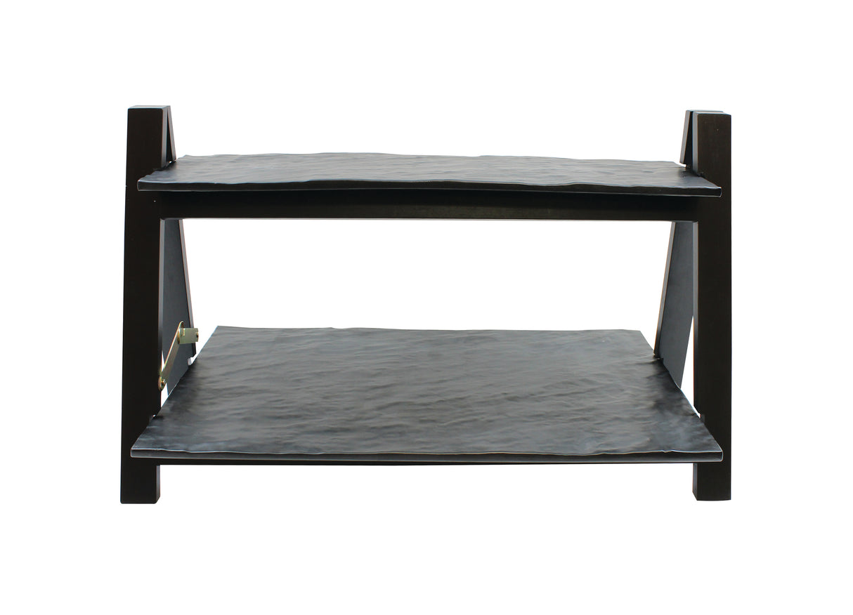 A two-tiered black metal rack from the TableCraft Products Frostone Collection, featuring two flat rectangular shelves supported by four angular legs, photographed against a plain white background. The riser set has slightly uneven surfaces.