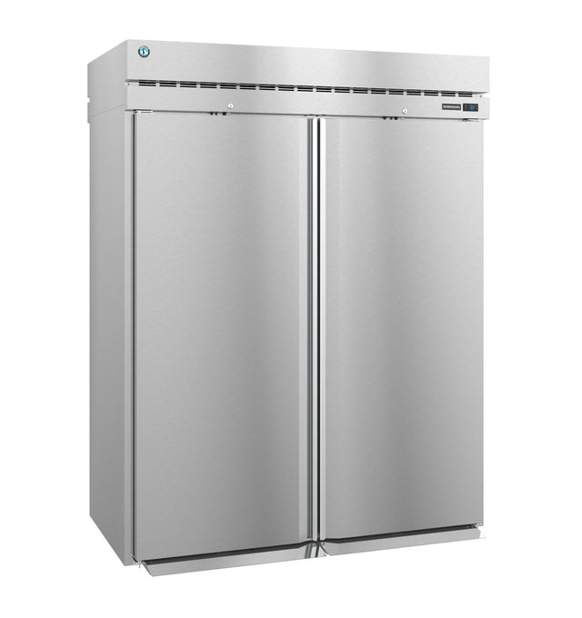 A large, industrial Steelheart Series Refrigerator stands upright with a smooth metallic finish, vertical handles, top ventilation, and a small round blue logo on the upper left. This commercial refrigerator is closed and unadorned, boasting a modern, sleek appearance.