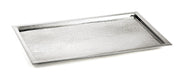 A rectangular TableCraft tray crafted from 18/8 stainless steel, featuring a slightly raised rim and a textured, hammered surface. Positioned at an angle on a white background, its clean edges highlight the modern, minimalist design.