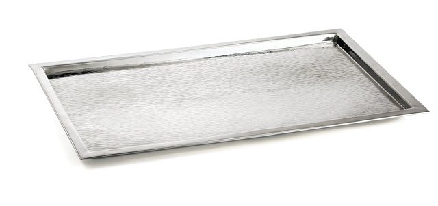 A rectangular TableCraft tray crafted from 18/8 stainless steel, featuring a slightly raised rim and a textured, hammered surface. Positioned at an angle on a white background, its clean edges highlight the modern, minimalist design.