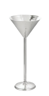 A tall, elegant martini glass from the Remington Collection, crafted in shiny hammered stainless steel with a wide conical bowl, long thin stem, and round base—all with a reflective silver finish—set against a white background.