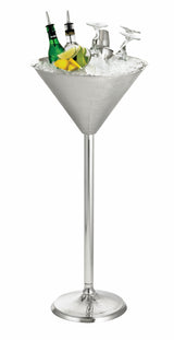A large, silver Remington Collection Martini Glass Beverage Stand on a tall stainless steel base holds ice, two green bottles, lemon and lime wedges, and two upside-down martini glasses for a modern, elegant display.