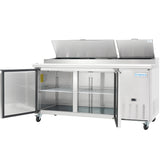 A commercial Empura Refrigeration stainless steel pizza prep table with two open top lids showing storage bins and two front doors revealing wire shelves. The unit is on wheels and features the Empura brand logo on the front.