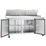 A stainless steel Empura Refrigeration pizza prep table with two open upper lids and two lower doors reveals clean, empty shelves inside. The unit is on wheels, features a wire shelf, and has a reflective interior.