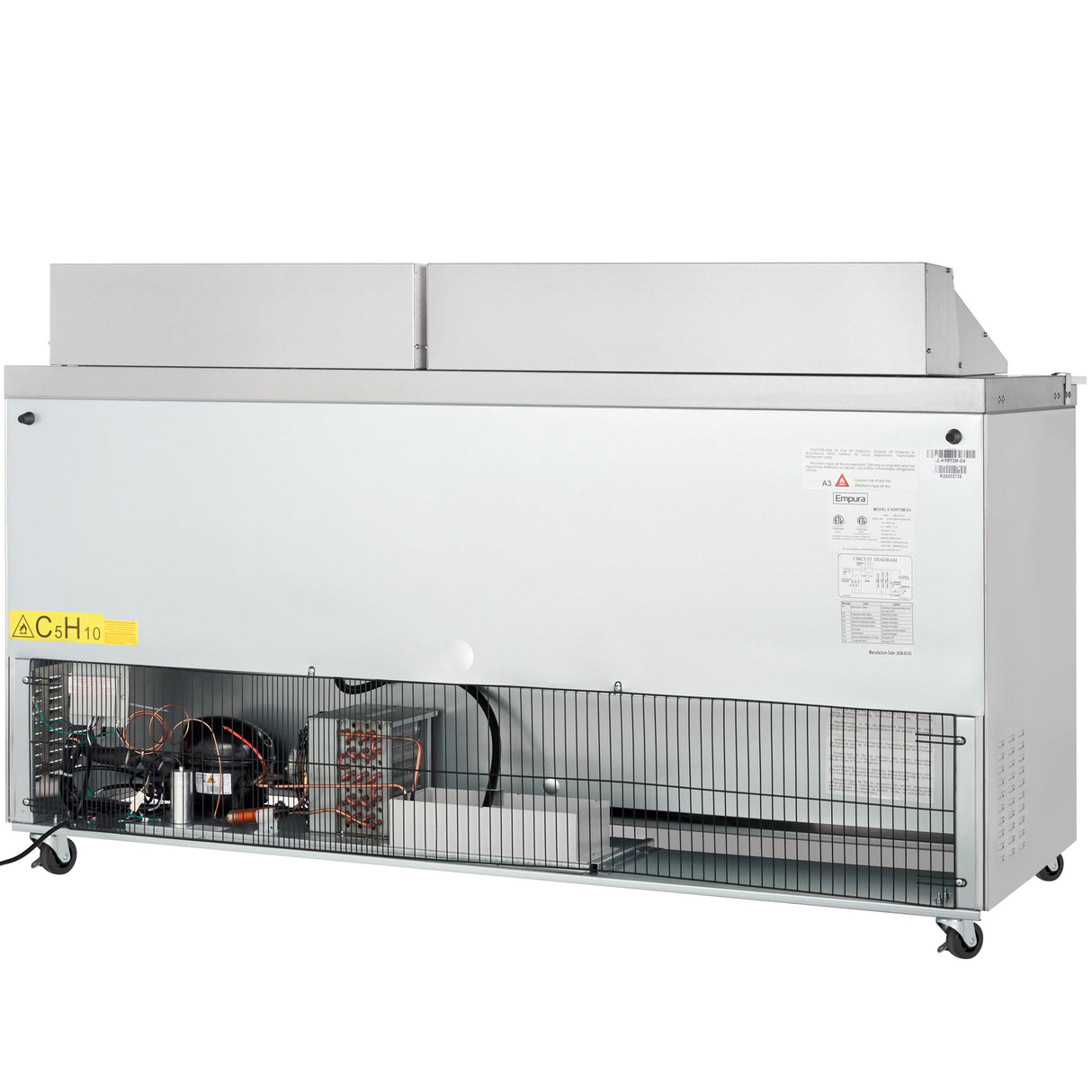 A commercial Empura refrigeration unit with its lower front panel removed exposes the cooling components, wiring, and compressor. The refrigerated sandwich prep table sits on four wheels, with warning and info labels on the right and a grille covering the exposed area.