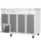 A white commercial kitchen freezer on wheels is shown from the back, featuring black metal cooling coils, a vented area with a fan, control panel, and product labels. This chest freezer has a solid lid with two latching handles on top.