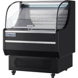 The Empura refrigeration display case features a curved glass front, black exterior, and LED lighting. This refrigerated display case sits on caster wheels for easy mobility and is perfect for showcasing food items in any open air merchandiser setting.