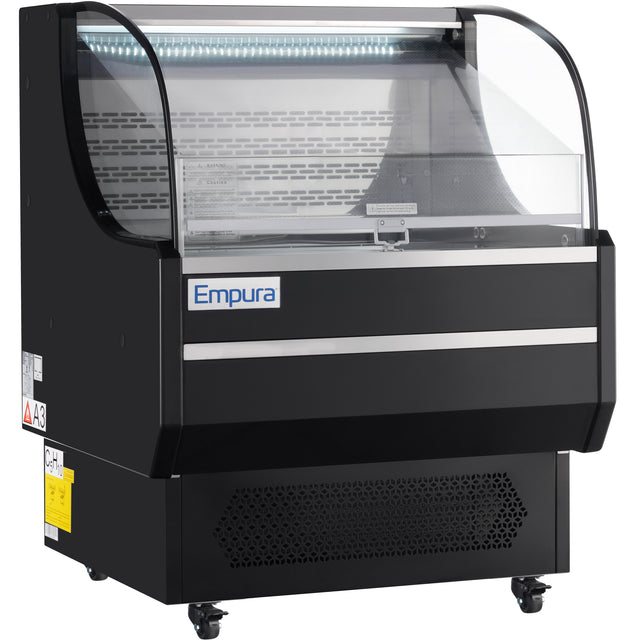 A black Empura refrigeration display with curved glass front and lit interior. This refrigerated display case has metal shelves, bottom vents, and wheels for mobility—ideal for showcasing chilled food or drinks in a store or cafe.