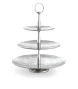 A three-tiered silver serving stand from the Remington Collection Serving Set features round, textured plates that decrease in size upward. The central column has a handle for easy carrying, and the background is plain white.