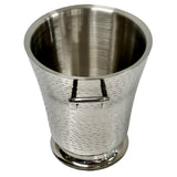 A Remington Collection Bucket, this stainless steel ice bucket features a tapered shape, textured surface, and small handle. Dishwasher safe and set against a white background, its reflective metal shows light distortions while the bucket remains empty.